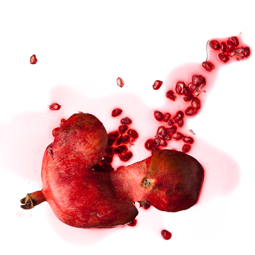 a minimalistic picture aesthetically showing a smashed grenadine fruit on pure white ground (no shadow)