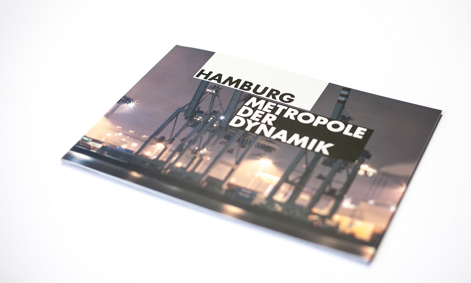 a photo of a closed brochure "hamburg – metropole of dynamic", cover picture shows cranes in the harbor