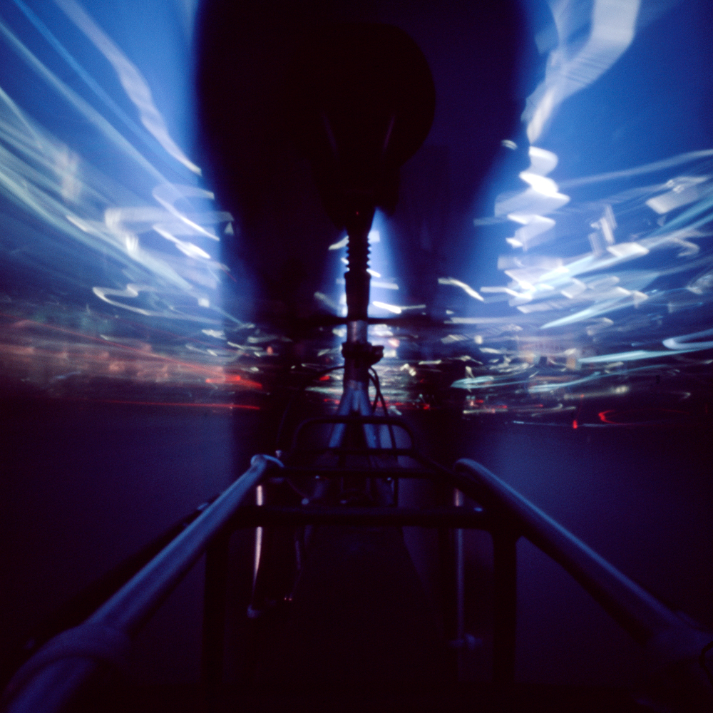 a pinhole camera picture: camera fixed on the back of a bike, showing blurred lines from a ride through the nightly city