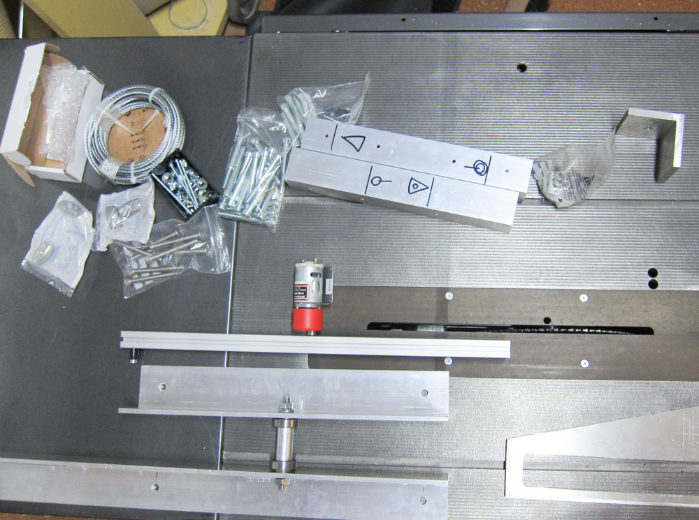 a documenting picture of different aluminium parts, a motor, angles, nuts and bolts